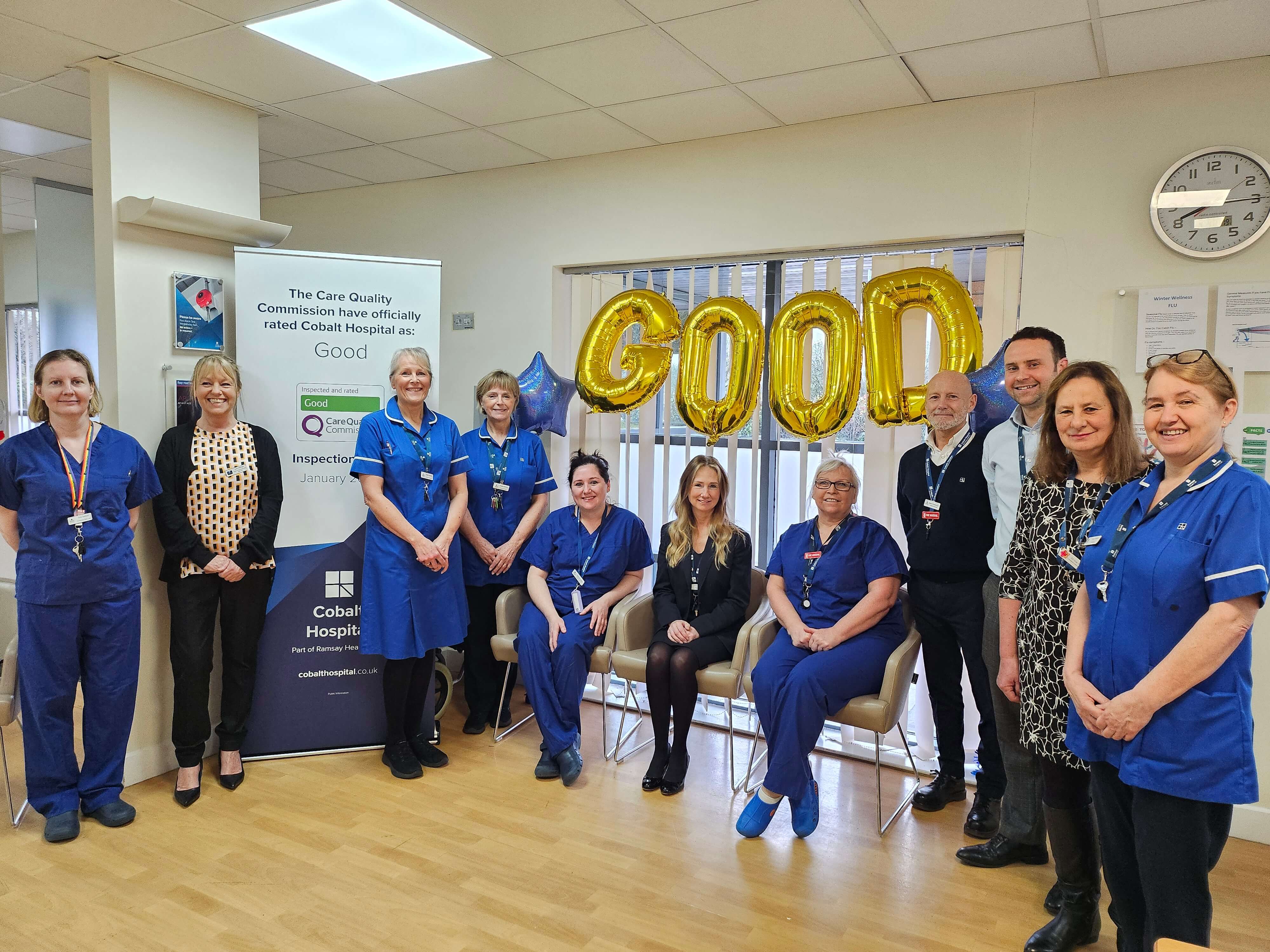 group of smiling hospital workers with 'good' balloons