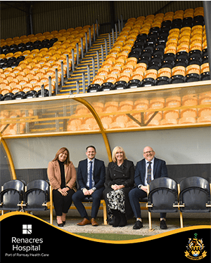 four people smiling in stadium